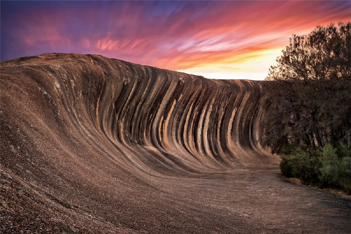 澳洲波浪岩（Wave Rock）并非是一个独立的岩石，而是连接北边一百公尺的海顿石及状似河马张口的荷马岩、骆驼岩等串连而成的风化岩石。澳州沙漠中的波浪岩如今在西澳洲已成为地标，早在25亿年前就已经形成。波浪岩名副其实就像一片席卷而来的波涛巨浪，波浪岩令无数的旅客赞叹大自然的鬼斧神工。
