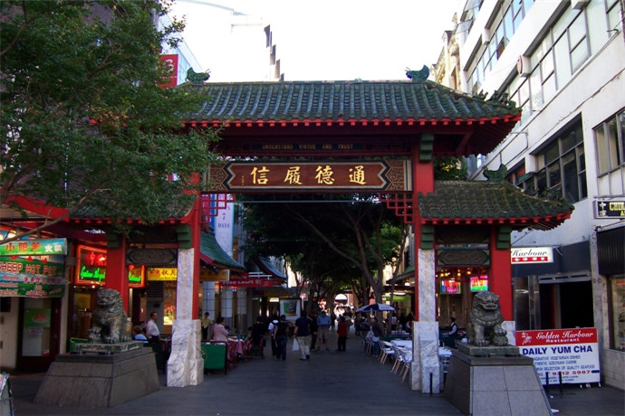 悉尼唐人街的中心-德信街道的两端，各竖立一座绿瓦红棂、玲珑标致的中国式牌楼。牌楼上的横额，各有“通德履信”和“四海一家”8个大字。